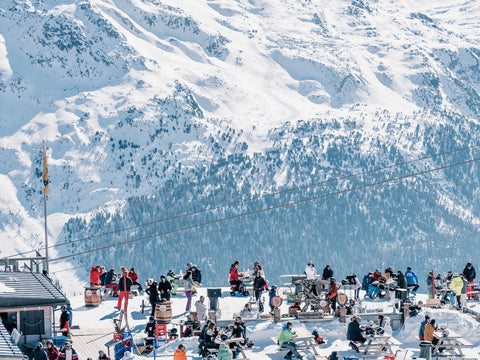 Alpina Attitude by Stuart Cantor - A photographic print capturing skiiers taking a break in the snowy mountains of St Moritz.