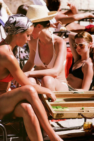 Backgammon by the Pool 2 by Slim Aarons - Vintage style women playing backgammon in swimmers