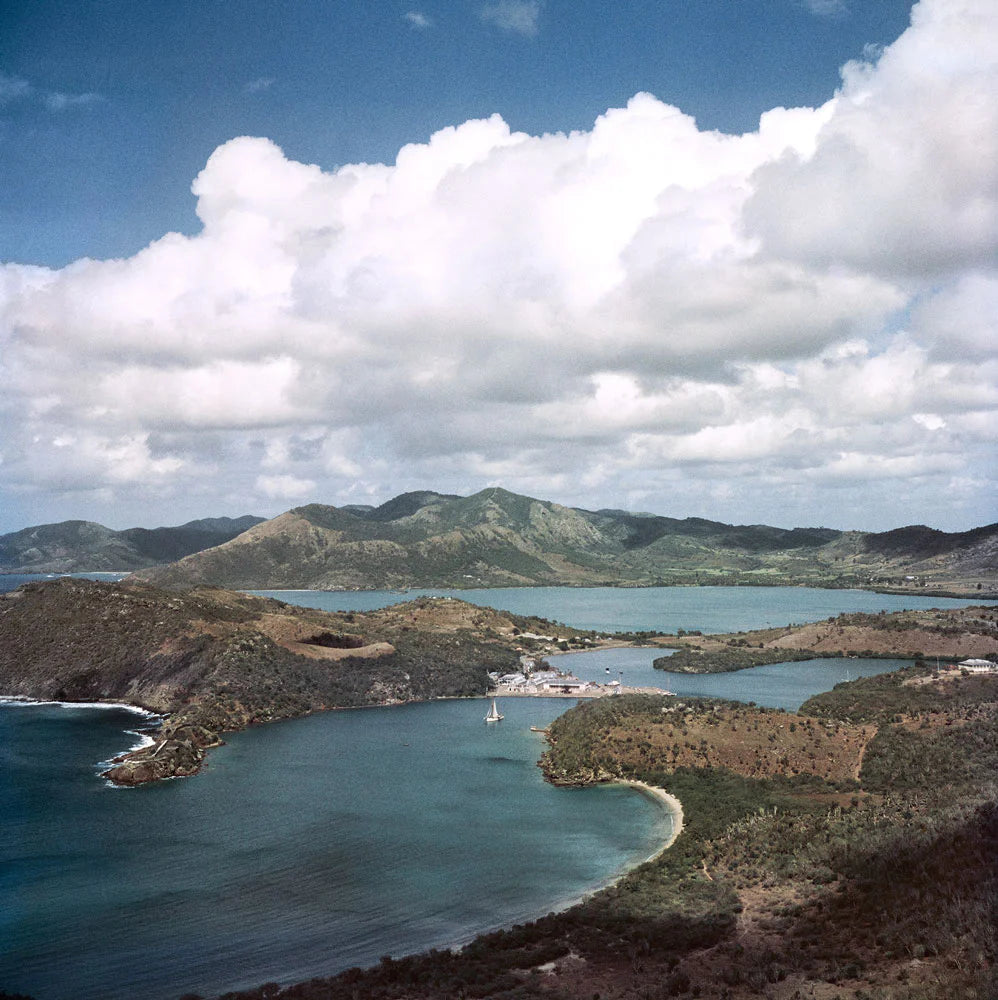 English Harbour Antigua by Slim Aarons - Coastal aerial photo with heavy white cloud cover.