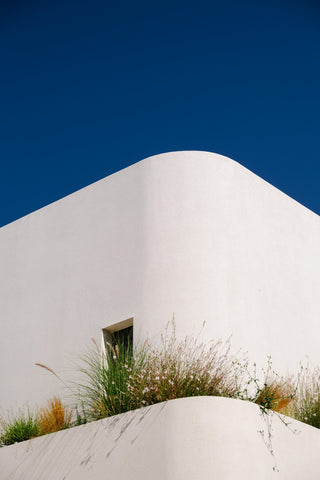 Greek Curves by Via Tolila - A photographic print of a beautiful building in Greece. The white curves contrast against a backdrop of clear blue sky.