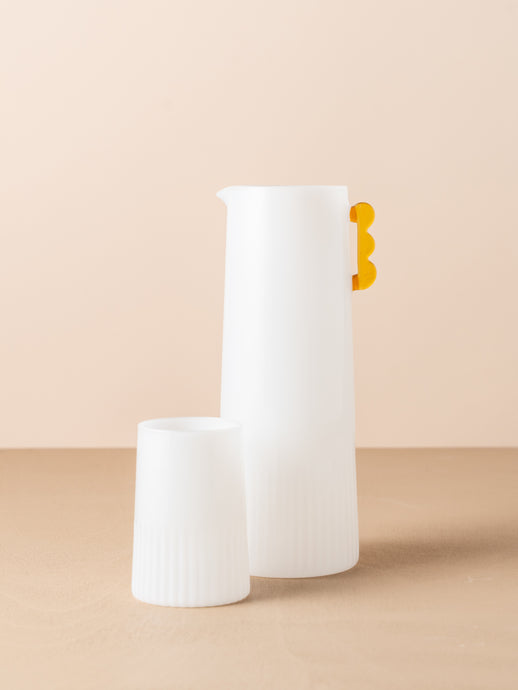 Kairos Carafe Opaque White by Saardé - An opqaue white glass carafe with ribbed texture and a amber handle.