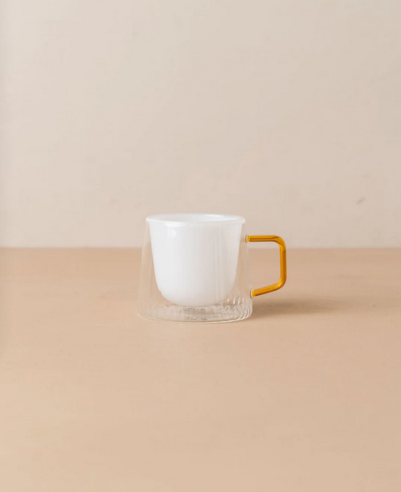 Kairos Coffee Cup Opaque White by Saardé - A glass coffee cup with an amber handle and an white well.