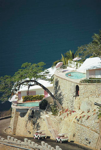 La Concha Beach Club 2 by Slim Aarons - View of cliffside pool with trees