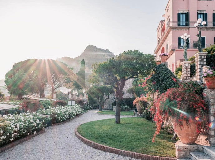 Ladies Waiting by Stuart Cantor - A photographic print of a garden scene in pink and green hues set in the Belmond Grand Hotel Timeo, Taormina, Sicily.