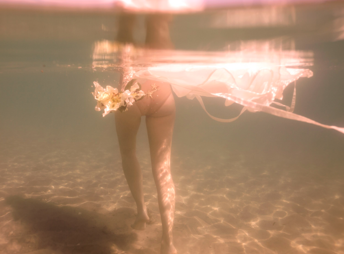Language of Flowers 2 by Francesca Owen - Underwater photography, walking through water in pink and neutral tones with flowers.