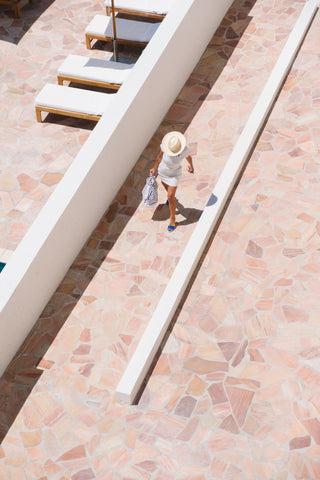 Les Roches Rouges by Via Tolila - A photographic print capturing a poolside holiday maker from a distance.