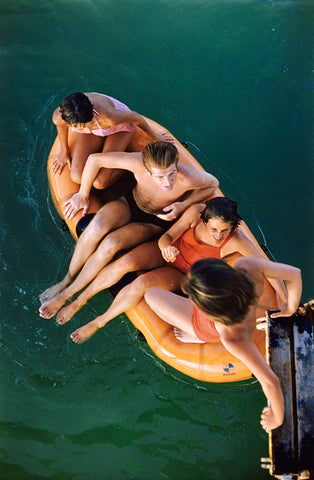 Lido Life 2 by Slim Aarons - four friends in floating in a lido