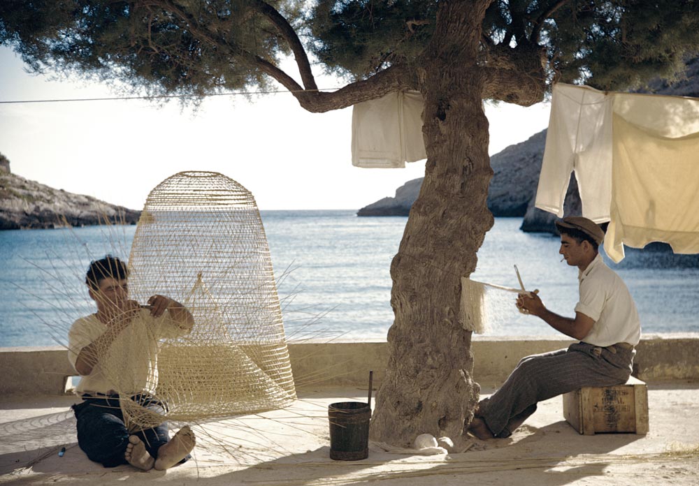 Maltese Fisherman 1952 by Slim Aarons - two men fishing by the sea