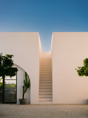 Masseria Morosità by Via Tolila - A photographic print of a white stone villa with a vibrant blue sky captured in Ostuni, Italy.