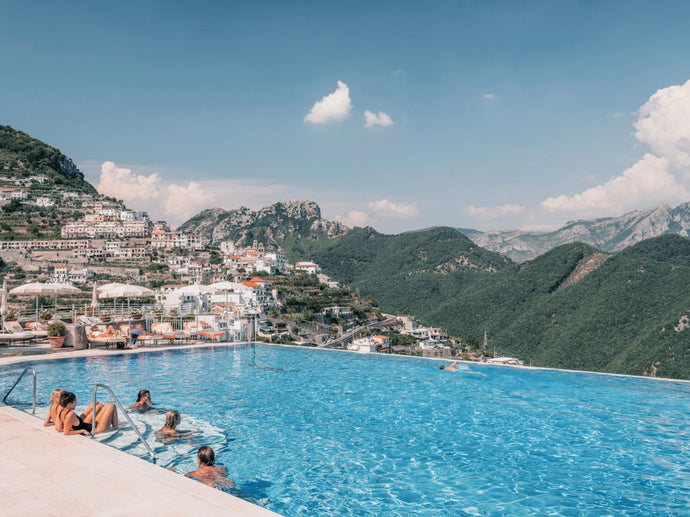 Poolside at Caruso by Stuart Cantor - A photographic print in blue and greens hues in a poolside scene with views across the Amalfi Coast.