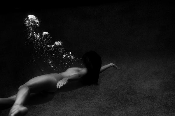 Signature Series #8 by Francesca Owen - A photographic art print of a woman lying at the bottom of a pool, viewed from underwater.