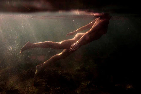 Signature Series - Blush 03 by Francesca Owen - A photographic art print of a woman swimming, viewed from underwater.