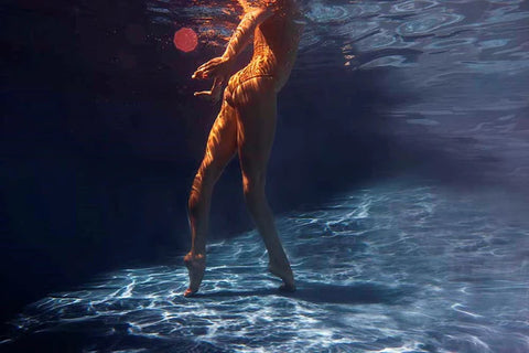 Signature Series - Glisten 05 by Francesca Owen - A photographic art print of a woman standing in a pool, viewed from underwater.
