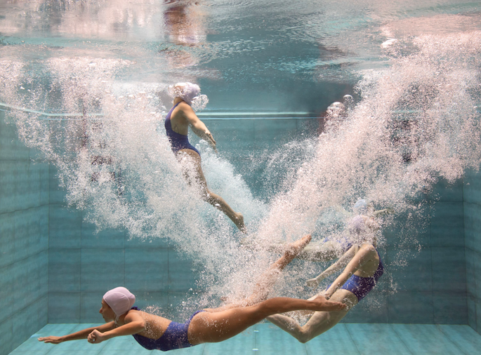 Singapore Mermaids 1 by Francesca Owen - Underwater photography of three synchronised swimmers in blue and white performing.