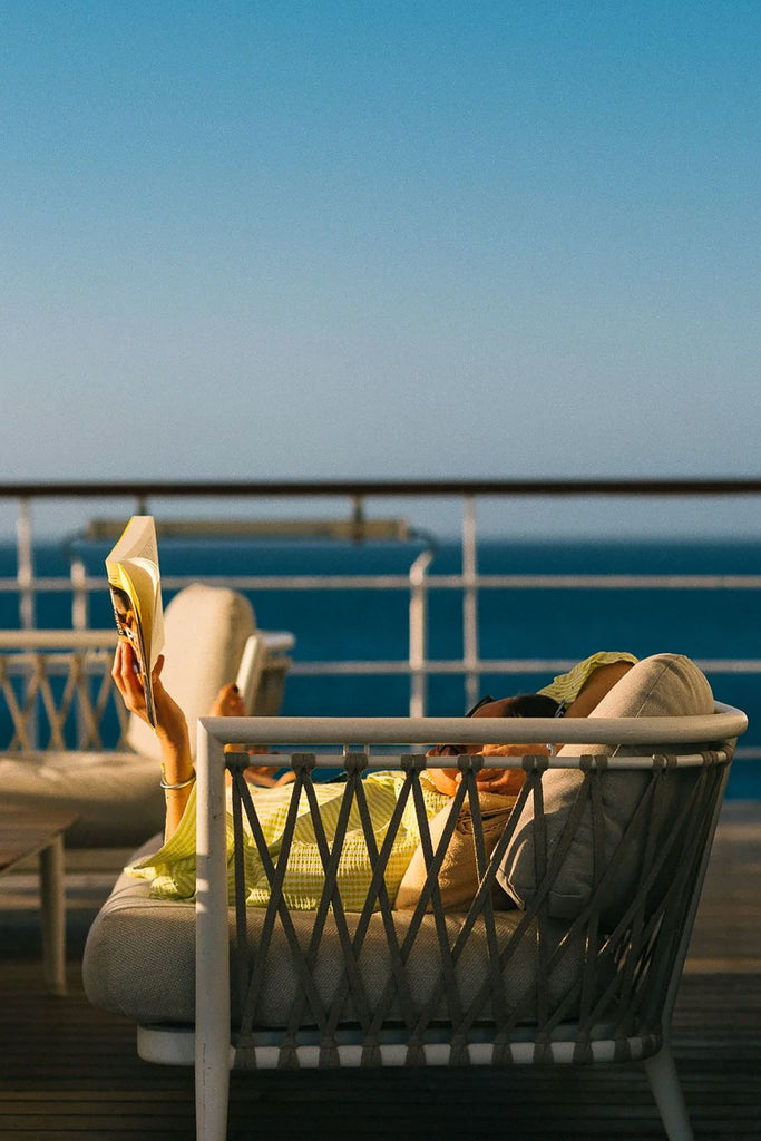 Sunset Hour by Via Tolila - Chair with a person sitting on a deck overlooking the ocean.