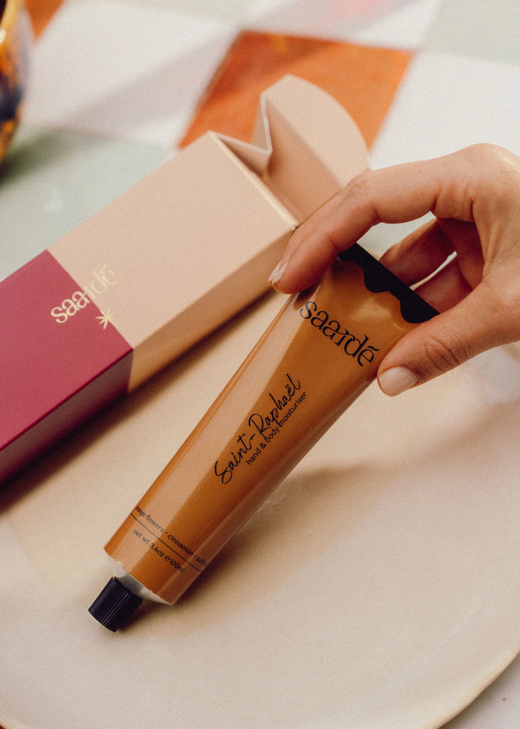 Bon Bon Moisturiser by Saarde - Hand holding a tube of 'Saint Raphael' hand cream with a box in the background