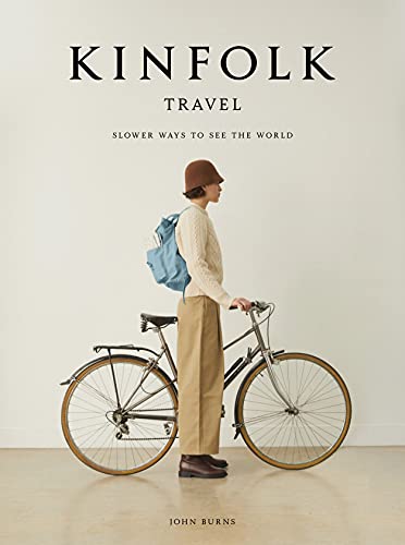 Kinfolk Travel by JOhn Burns - Travel book cover with title and author and women with hat on standing next to bicycle.