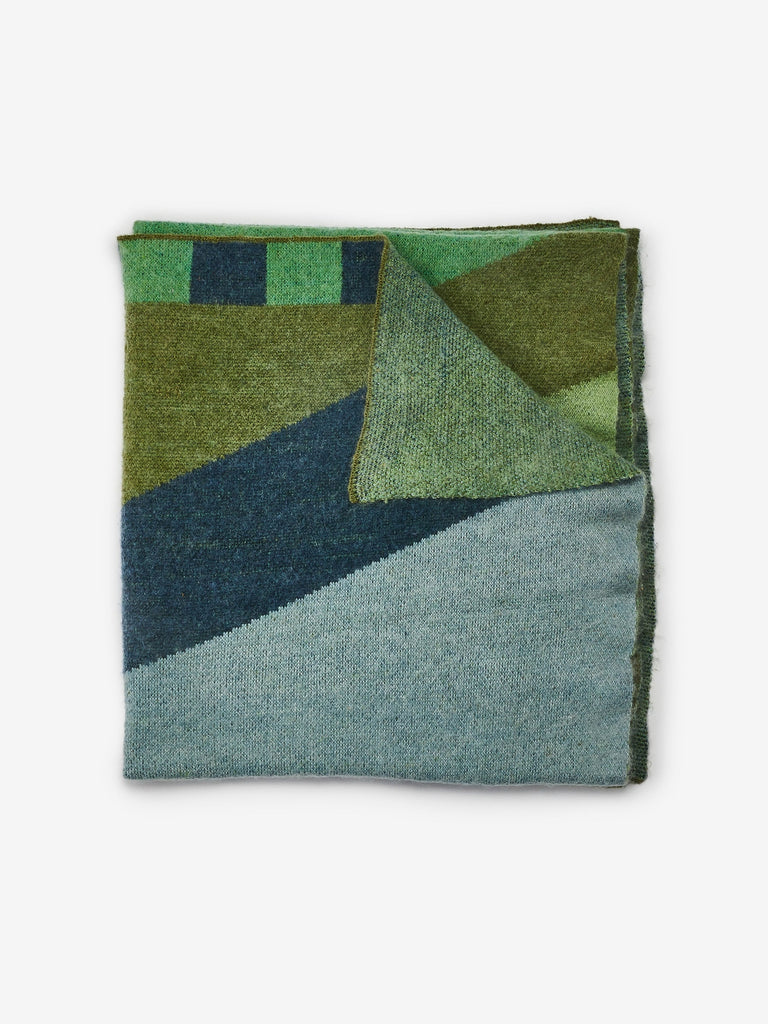 Geometric Green Mohair Throw - Geometric blue and green shapes on folded blanket on white background.