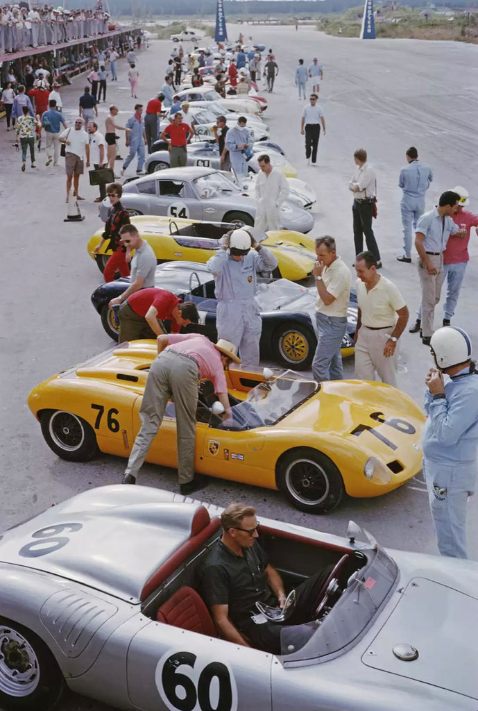  Bahamas Speed Week by Slim Aarons -  A vintage photo from the 1960s of race cars lined up and drivers and crew readying for a race start.