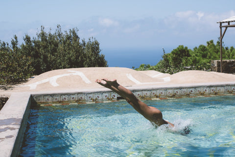 Dive, Sicily by Dina Broadhurst - Photograph of a swimming pool with a lady diving into the water nude