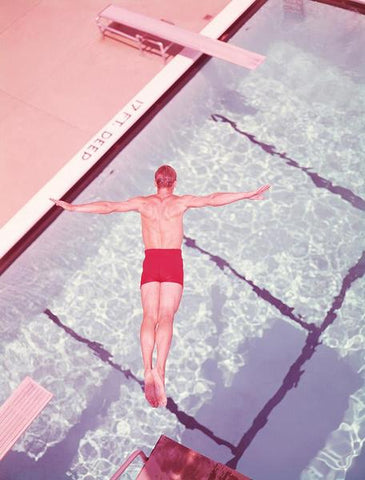 Dive, Circa 1950 by FINEPRINT co - A vintage photograph of a man diving off a diving board into a pool in pastel tones.
