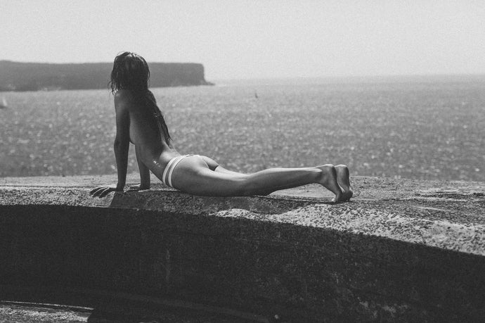 In A Beautiful World by Dina Broadhurst - A beautiful, calm image, of a black and white portrait of a figure in a bikini with the glittering ocean in the background.