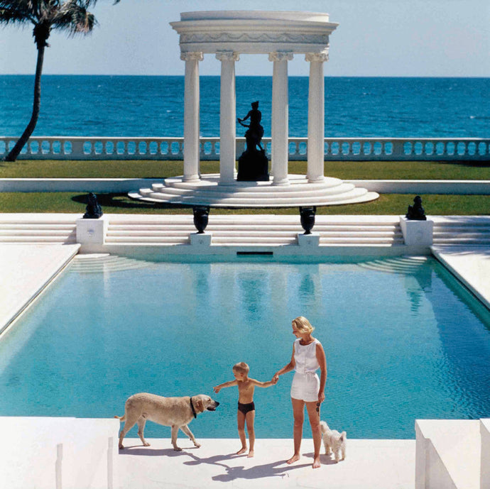 Nice Pool by Slim Aarons - Standing in fron of her Grecian pool, C.Z Guest holds her son's hand while their two dogs stand beside them.