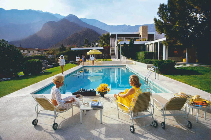 Poolside Gossip by Slim Aarons - A photograph of a Mid Century Modern home in Palm Springs, captured in 1970 by Slim Aarons featuring partygoers by the pool.