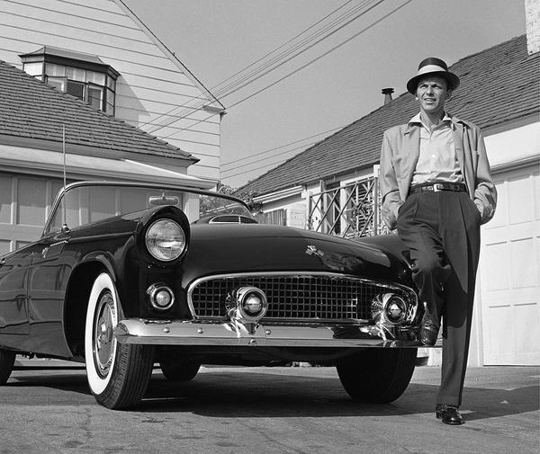 Sinatra And His Tbird by Getty Images (UK) Ltd - Black and white photograph of Frank Sinatra leaning on his Ford Thunderbird in the driveway of his home in 1955