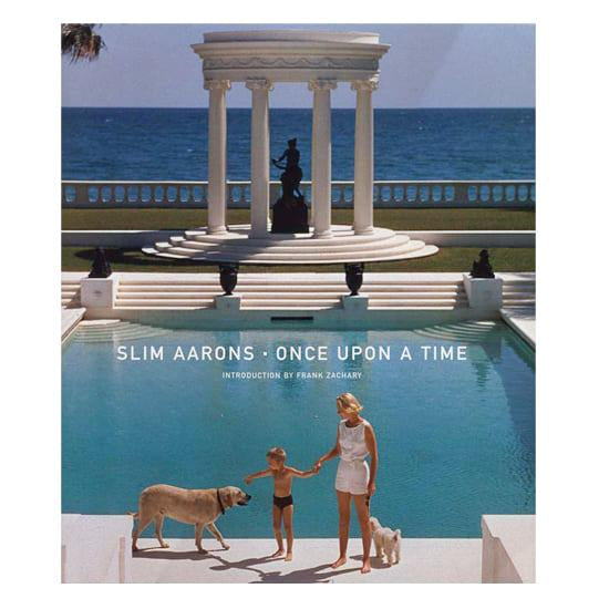 Slim Aarons, Once Upon a Time by Frank Zachary - A woman and child with two dogs standing on the edge of a pool with greek columns overlooking the ocean