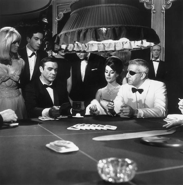 Thunderball by Getty Images (UK) Ltd - Seated at a poker table, Sean Connery, as James Bond is captured in black and white in the casino scene from the film 'Thunderball', 1965. Glamorous onlookers in exquisite gowns and tuxedos