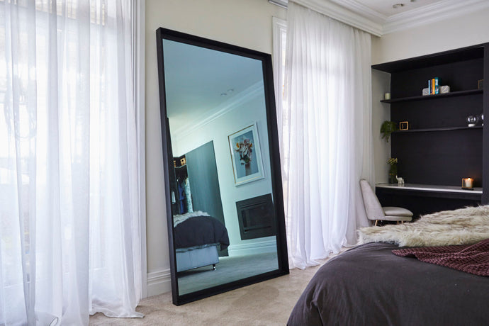 Leaner TV-Mirror with Black Frame by FRAMING TO A T - TV Mirror with black frame leaning against a bedroom wall