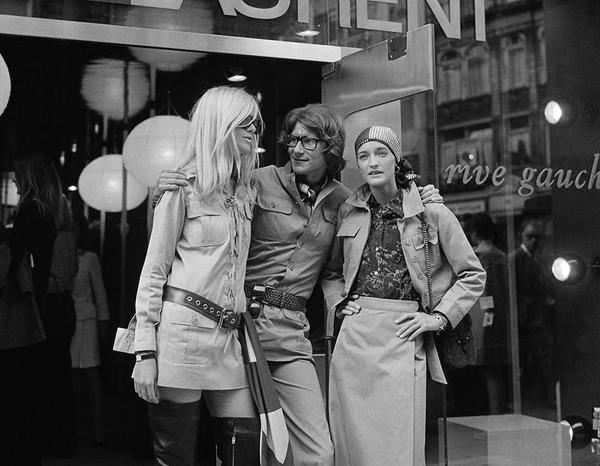 Yves Saint Laurent by Getty Images (UK) Ltd - Black and white vintage photograph of Yves Saint Laurent, French designer posing with two fashion models, Betty Catroux (left) and Loulou de la Falaise, outside his 'Rive Gauche' shop
